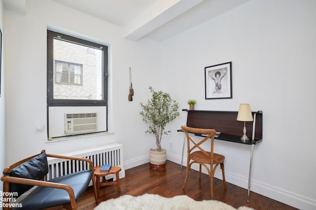 sitting room with dark wood-type flooring, cooling unit, and radiator