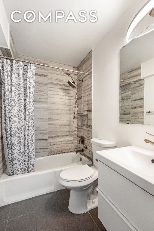 full bathroom with shower / bathtub combination with curtain, tile patterned floors, vanity, and toilet