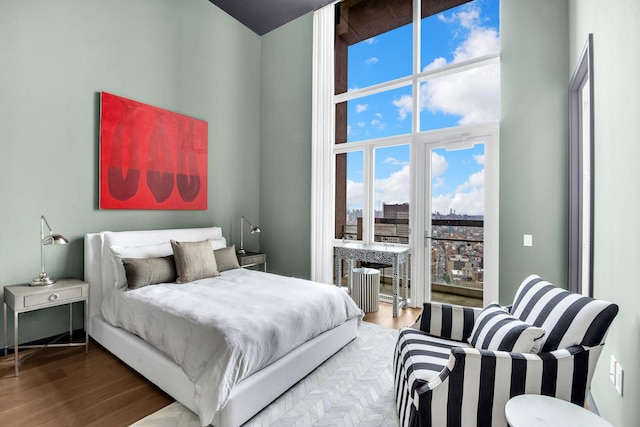 bedroom featuring a city view and wood finished floors