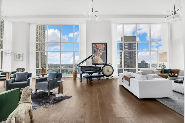 living room with wood-type flooring, a notable chandelier, and a wealth of natural light