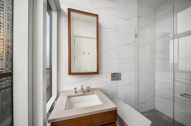 bathroom featuring a stall shower, tile walls, and vanity