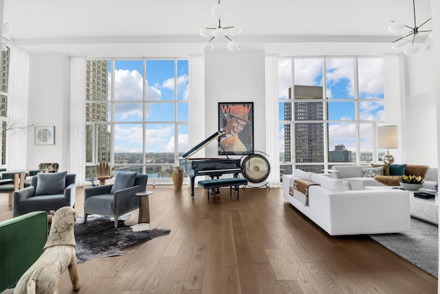 living room featuring a view of city, a notable chandelier, dark wood-style flooring, and expansive windows