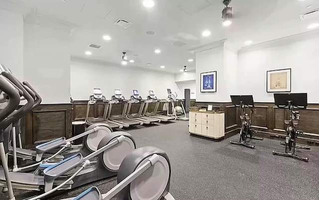 exercise room with a wainscoted wall, a decorative wall, recessed lighting, and visible vents