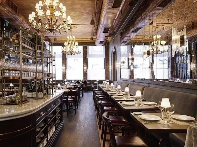 dining area featuring dark wood-type flooring and a notable chandelier