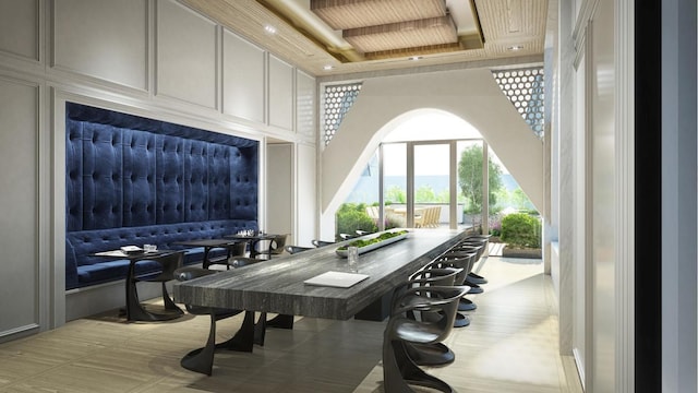 dining room featuring a towering ceiling and a decorative wall