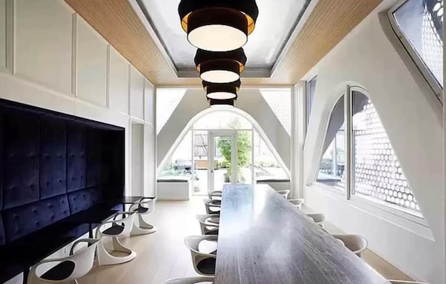 interior space with light wood-type flooring and a raised ceiling