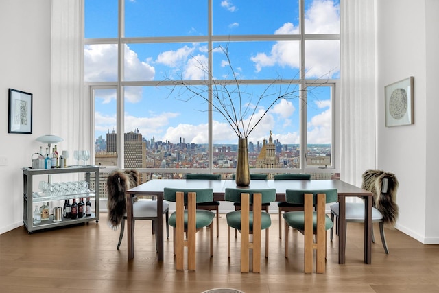 dining area featuring a city view, wood finished floors, and floor to ceiling windows