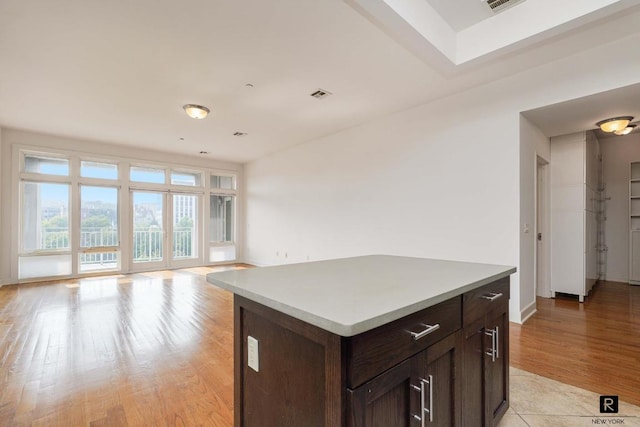 kitchen with dark brown cabinetry, light hardwood / wood-style flooring, and a kitchen island