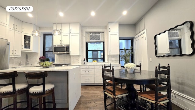 kitchen featuring white cabinetry, appliances with stainless steel finishes, and hanging light fixtures