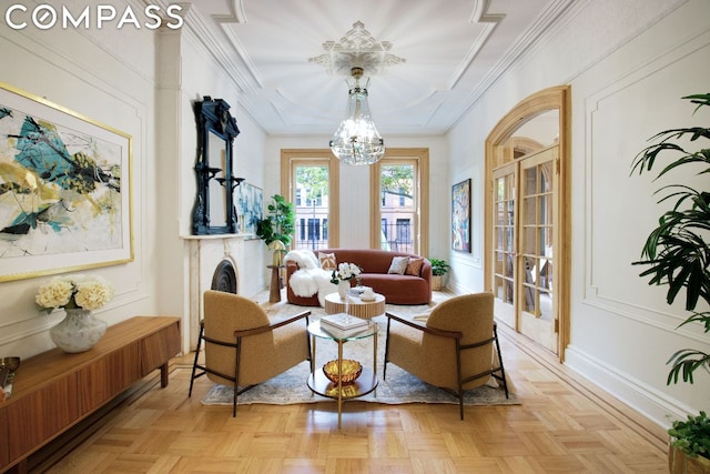 living area featuring an inviting chandelier, ornamental molding, french doors, and light parquet floors