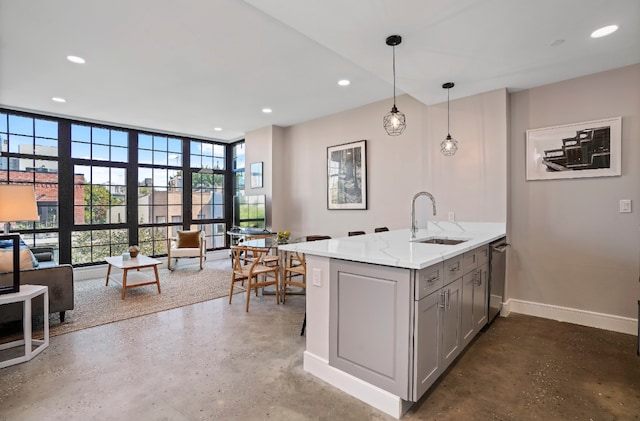 kitchen with floor to ceiling windows, kitchen peninsula, dishwasher, pendant lighting, and light stone counters