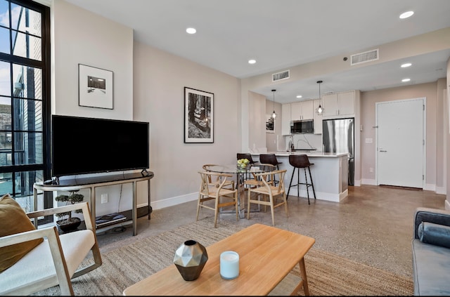 living room featuring speckled floor, baseboards, visible vents, and recessed lighting