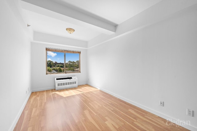 unfurnished living room featuring heating unit, hardwood / wood-style flooring, and beam ceiling