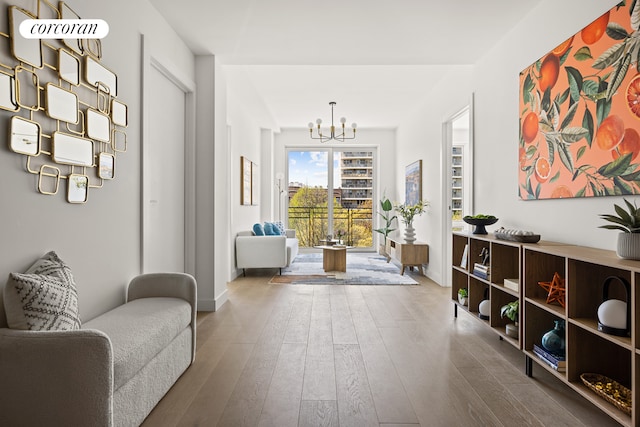 interior space with a notable chandelier, baseboards, and hardwood / wood-style floors