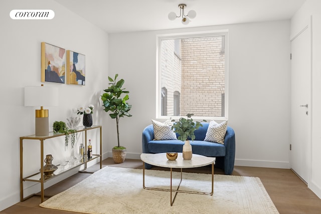 sitting room with wood finished floors, visible vents, and baseboards