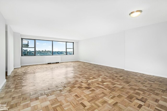 spare room featuring baseboards and radiator heating unit