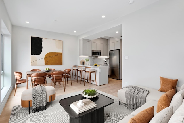 living area featuring light wood-type flooring and recessed lighting