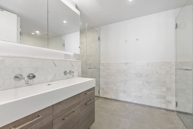 bathroom featuring tile walls, an enclosed shower, and vanity