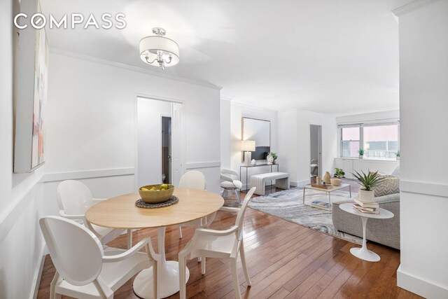 dining room with crown molding and hardwood / wood-style flooring