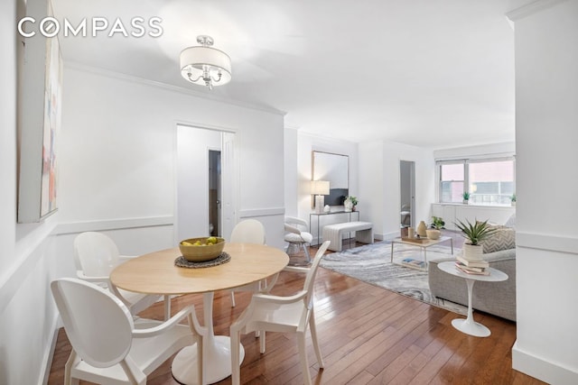 dining area featuring ornamental molding and hardwood / wood-style floors