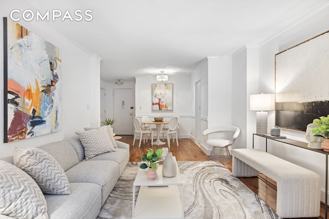 living area featuring ornamental molding and wood finished floors