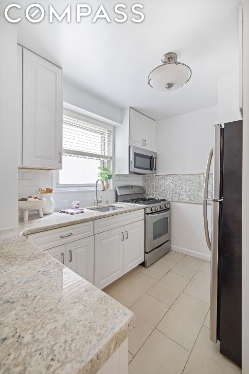 kitchen featuring white cabinetry, stainless steel appliances, sink, and decorative backsplash