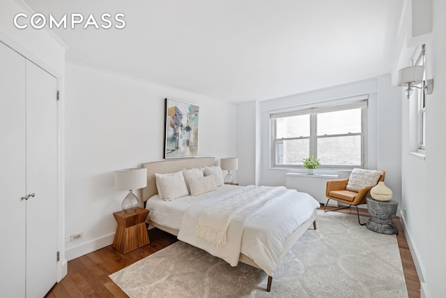 bedroom with baseboards and wood finished floors