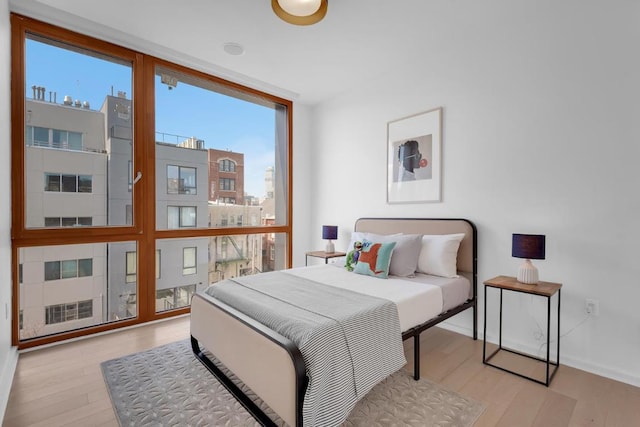 bedroom featuring light hardwood / wood-style floors and floor to ceiling windows