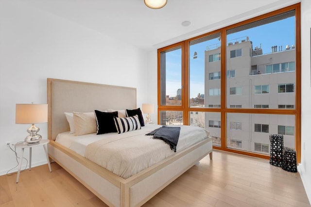 bedroom featuring light hardwood / wood-style flooring and floor to ceiling windows