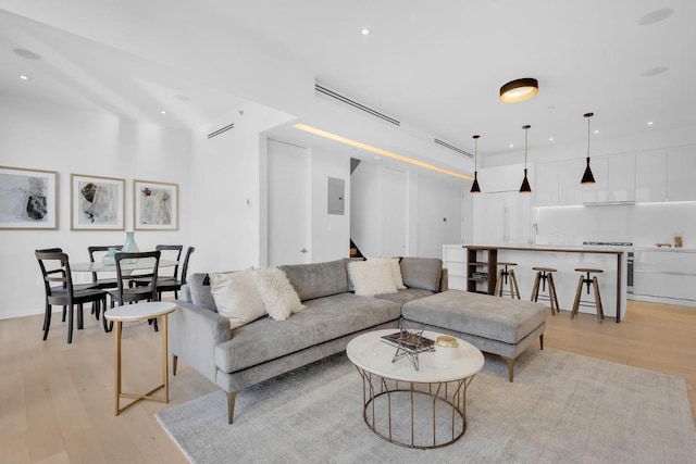 living room featuring stairway, recessed lighting, visible vents, and light wood-style floors