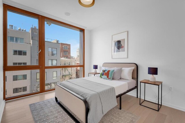 bedroom featuring light hardwood / wood-style flooring and floor to ceiling windows