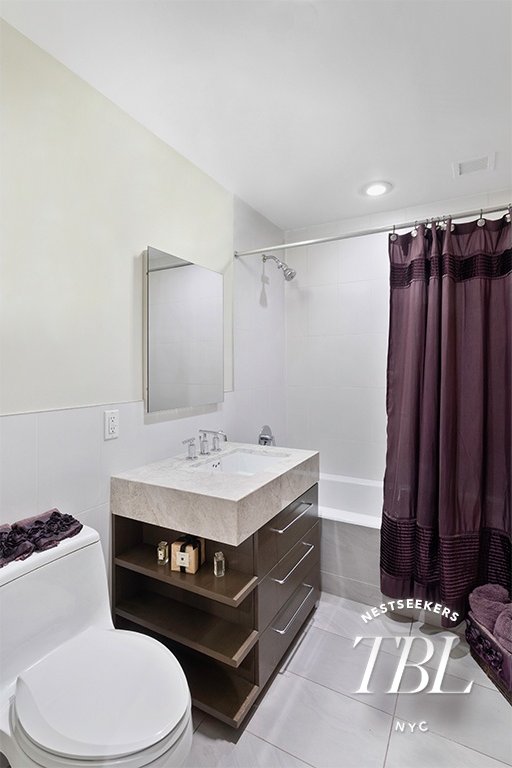 full bathroom featuring toilet, tile walls, vanity, shower / bath combination with curtain, and tile patterned flooring