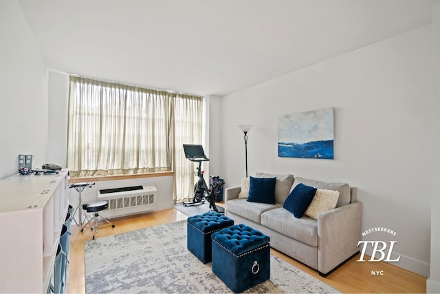 living room with hardwood / wood-style flooring and an AC wall unit