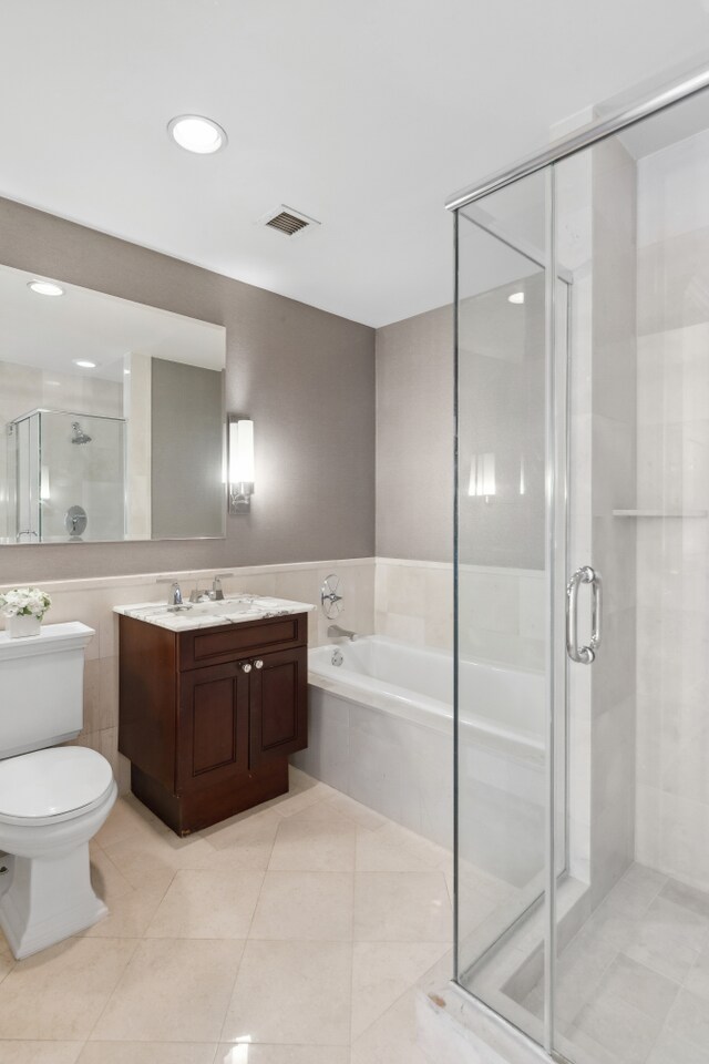 bathroom featuring toilet, vanity, visible vents, a shower stall, and a bath