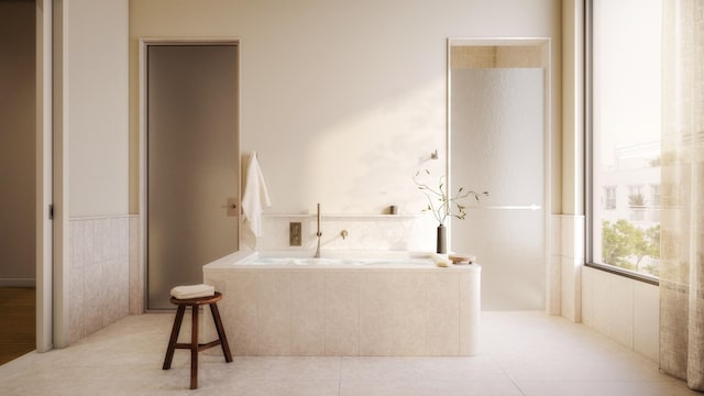 bathroom with a garden tub and tile patterned floors