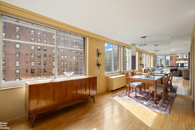 dining room with baseboards, hardwood / wood-style flooring, and crown molding