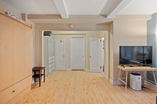 interior space with baseboards, beam ceiling, and wood finished floors