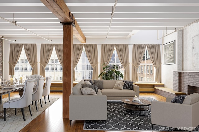 living room featuring plenty of natural light, beamed ceiling, a fireplace, and wood finished floors