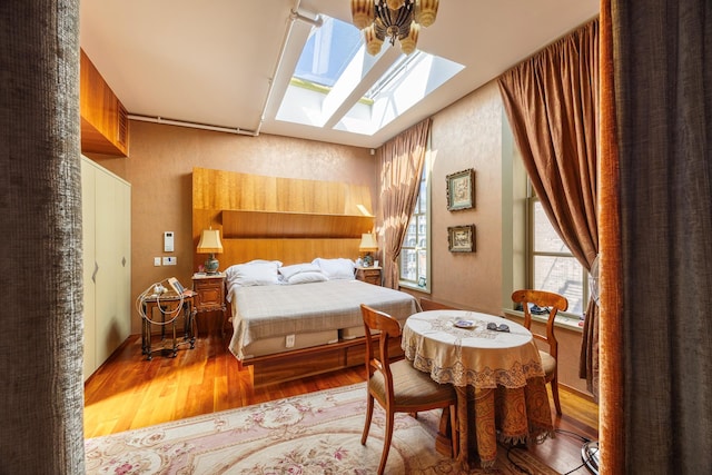 bedroom with wood finished floors and a skylight