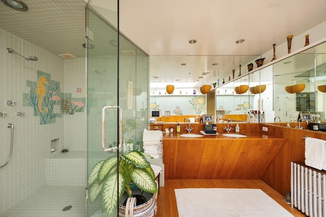 full bathroom featuring a shower stall, vanity, and wood finished floors