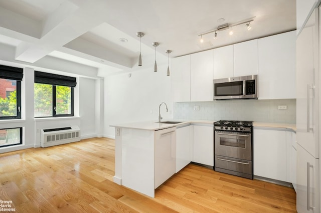 kitchen with kitchen peninsula, white cabinets, and appliances with stainless steel finishes