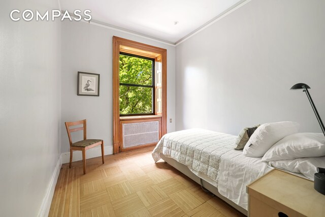 bedroom featuring light parquet floors and ornamental molding