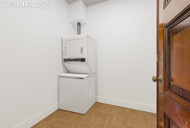 laundry room featuring light parquet flooring and stacked washing maching and dryer