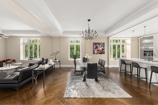 living room with ornamental molding, a baseboard radiator, a raised ceiling, and a notable chandelier