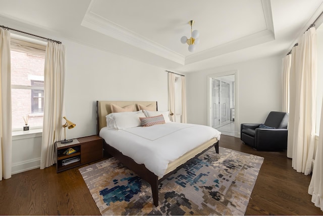 bedroom featuring a tray ceiling, wood finished floors, and crown molding