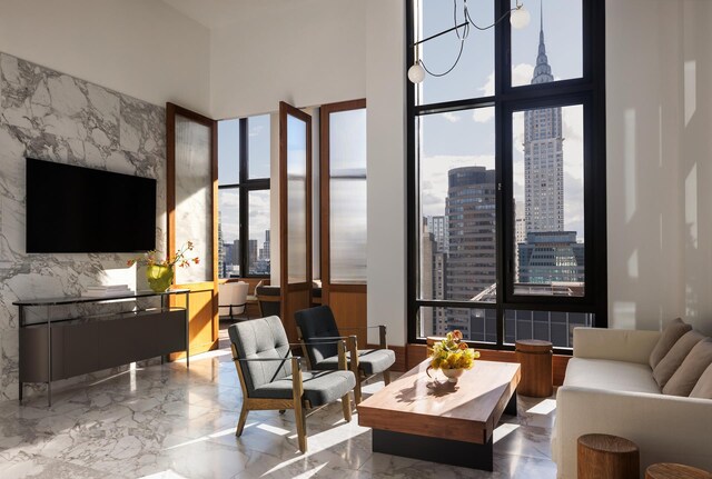 living area with a city view, marble finish floor, and a high ceiling