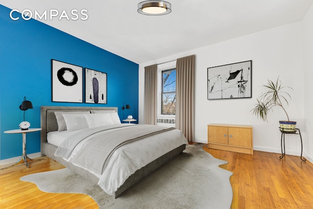 bedroom with baseboards and wood finished floors