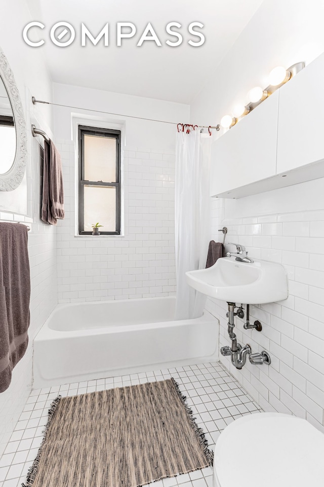 bathroom featuring tile patterned floors, shower / tub combo with curtain, tile walls, and toilet