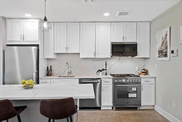 kitchen with stainless steel appliances, sink, pendant lighting, and white cabinets