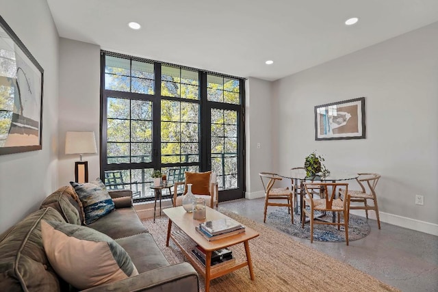 living room with a wall of windows and concrete floors